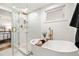 Luxurious bathroom with a freestanding tub, walk-in shower, gold fixtures, and modern tile at 9405 W 54Th Pl, Arvada, CO 80002