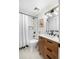 Modern bathroom featuring a shower-tub combo, wood vanity, modern hardware, and black and white accents at 9405 W 54Th Pl, Arvada, CO 80002