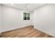 Empty bedroom with new floors, white walls, a ceiling fan and ample natural light from the window at 9405 W 54Th Pl, Arvada, CO 80002