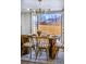 Close up of the dining room table, highlighting the modern light fixture and view through the french doors at 9405 W 54Th Pl, Arvada, CO 80002