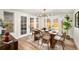 Bright dining room with modern light fixture, wooden table, and french doors leading to the backyard at 9405 W 54Th Pl, Arvada, CO 80002