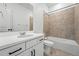 Bathroom with white vanity, chrome fixtures, and a shower-over-tub with tile surround at 17747 Prairie Peak Trl, Parker, CO 80134