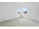 Sunlit bedroom with neutral carpet and two large windows providing pleasant views at 17747 Prairie Peak Trl, Parker, CO 80134