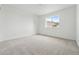 Bright bedroom features neutral carpet, white walls, and a large window at 17747 Prairie Peak Trl, Parker, CO 80134