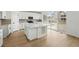 Modern kitchen with sleek white cabinets, an island, and stainless steel appliances at 17747 Prairie Peak Trl, Parker, CO 80134