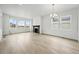 Bright and airy living room featuring hardwood floors, large windows, and a charming fireplace at 17747 Prairie Peak Trl, Parker, CO 80134