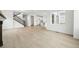 Open-concept living space with hardwood floors, staircase, and a view into the modern kitchen at 17747 Prairie Peak Trl, Parker, CO 80134