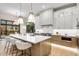 Modern kitchen with a large island, white shaker cabinets, and stainless steel appliances at 6551 S Harlan Ct, Littleton, CO 80123