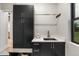 Functional laundry room with dark cabinetry and a large sink at 6551 S Harlan Ct, Littleton, CO 80123