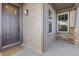 Close-up view of the covered front porch featuring stylish wood accents, a secure entry, and good lighting at 17412 W 93Rd Pl, Arvada, CO 80007