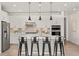 Well-lit kitchen with a central island, bar seating, stainless steel appliances, and ample counter space at 17412 W 93Rd Pl, Arvada, CO 80007