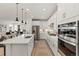 Modern kitchen with white cabinets, stainless steel appliances, a large island, and pendant lighting at 17412 W 93Rd Pl, Arvada, CO 80007