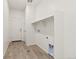 A pristine laundry room with wood-look floors and storage options offers a clean and efficient space for chores at 17412 W 93Rd Pl, Arvada, CO 80007