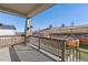 Serene covered patio with stone pillars and wooden railing, offering a tranquil outdoor space with beautiful hillside views at 17412 W 93Rd Pl, Arvada, CO 80007
