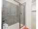 Modern shower featuring glass door, light gray tile, and built-in shelving for an elegant and functional design at 17412 W 93Rd Pl, Arvada, CO 80007