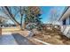 Spacious backyard with mature trees, natural landscaping, and a rock feature at 2230 Miller Ct, Lakewood, CO 80215