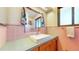 Vintage-style bathroom with pink tiling, a large mirror, and a white rectangular sink at 2230 Miller Ct, Lakewood, CO 80215