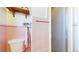 Bathroom features pink tiling, a white toilet, a metal towel rack, and a glass shower door at 2230 Miller Ct, Lakewood, CO 80215