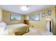 Well-lit bedroom with two windows, and a bed with light yellow bedding at 2230 Miller Ct, Lakewood, CO 80215