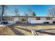 Back exterior view of a single-story home featuring a sunroom and large windows at 2230 Miller Ct, Lakewood, CO 80215