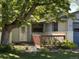 A welcoming entrance with decorative door, wood deck, and lush garden bed at 2230 Miller Ct, Lakewood, CO 80215