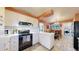 Bright kitchen with white cabinetry, complementary backsplash, and view to dining area at 2230 Miller Ct, Lakewood, CO 80215