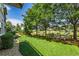 Expansive backyard with manicured lawn, mature trees, and cozy lounge chairs at 2980 Craig Ct, Castle Rock, CO 80109