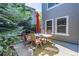 Back patio with outdoor dining set, shaded by a mature evergreen tree at 2980 Craig Ct, Castle Rock, CO 80109