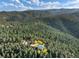Breathtaking aerial view of the property nestled within a dense forest, offering privacy and stunning natural beauty at 2785 Magpie Ln, Larkspur, CO 80118