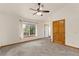 Large bedroom with neutral carpet, a ceiling fan and a window with backyard views and natural light at 2785 Magpie Ln, Larkspur, CO 80118