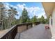 Large wooden deck with railing and scenic views of the forest at 2785 Magpie Ln, Larkspur, CO 80118