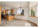 A light, open dining area with a window to nature on the side and a look at the kitchen at 2785 Magpie Ln, Larkspur, CO 80118
