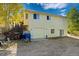 A two-story, light-yellow home with a garage and access to the deck with stairs, surrounded by trees and nature at 2785 Magpie Ln, Larkspur, CO 80118