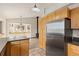Open kitchen features wooden cabinetry, stainless steel appliances, tile flooring, and backyard views at 2785 Magpie Ln, Larkspur, CO 80118