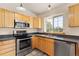 Stainless steel appliances compliment the light wood cabinets in this kitchen with a view of nature outside the window at 2785 Magpie Ln, Larkspur, CO 80118