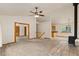 Bright, neutral living space boasts a ceiling fan, wood accents, natural light, carpet, and a view to the kitchen at 2785 Magpie Ln, Larkspur, CO 80118