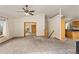 A view of the living room with carpeted floors, wood accents and a kitchen in the background at 2785 Magpie Ln, Larkspur, CO 80118
