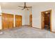 Large bedroom with neutral carpet, three closets, and a view into the main bathroom with tile floors at 2785 Magpie Ln, Larkspur, CO 80118
