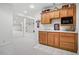 Basement bar with wood cabinets, microwave, sink and extra space at 7276 Brighton Ct, Castle Pines, CO 80108