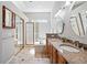 Bright bathroom featuring a double vanity with granite countertops, framed mirrors and a shower at 7276 Brighton Ct, Castle Pines, CO 80108