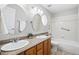 Bathroom featuring a double vanity, framed mirrors, tiled tub and shower at 7276 Brighton Ct, Castle Pines, CO 80108