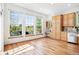 Sun-filled dining area with large windows, wooden floors, and built-in cabinets offering ample storage at 7276 Brighton Ct, Castle Pines, CO 80108