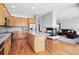 Bright kitchen features stainless appliances, center island with seating, and flows into the living area with fireplace at 7276 Brighton Ct, Castle Pines, CO 80108
