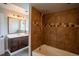 Modern bathroom featuring a dark wood vanity, mirror and tiled shower at 17863 Fringed Sage Way, Parker, CO 80134