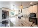 Bright kitchen with stainless steel appliances, white cabinets, and a large island at 17863 Fringed Sage Way, Parker, CO 80134