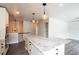 Modern kitchen island with stone countertop overlooking hardwood floors and open space at 17863 Fringed Sage Way, Parker, CO 80134