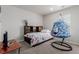 Bedroom with a hanging chair, bed with patterned bedding, and modern decor at 23998 E Atlantic Pl, Aurora, CO 80018