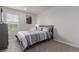 Bedroom showcasing a large window, comfortable bed with striped bedding, and modern decor at 23998 E Atlantic Pl, Aurora, CO 80018