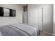 A bedroom featuring a TV, large closet, and comfortable bed with striped gray and white bedding at 23998 E Atlantic Pl, Aurora, CO 80018