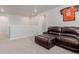 Open loft area with neutral carpeting, a dark brown leather sofa, and natural lighting at 23998 E Atlantic Pl, Aurora, CO 80018